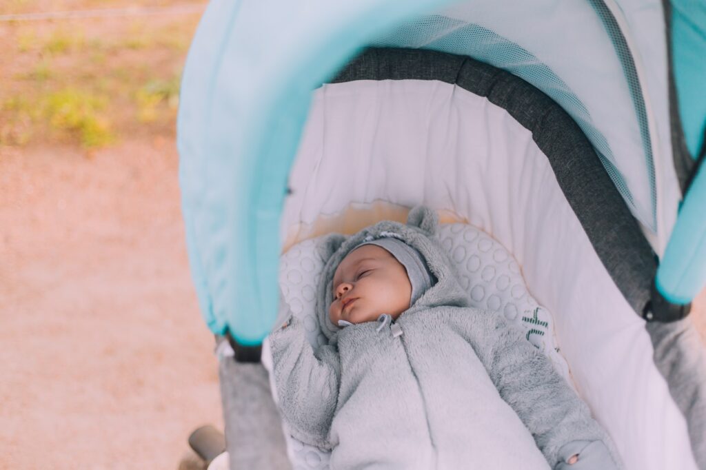The baby sleeps in a stroller on the street